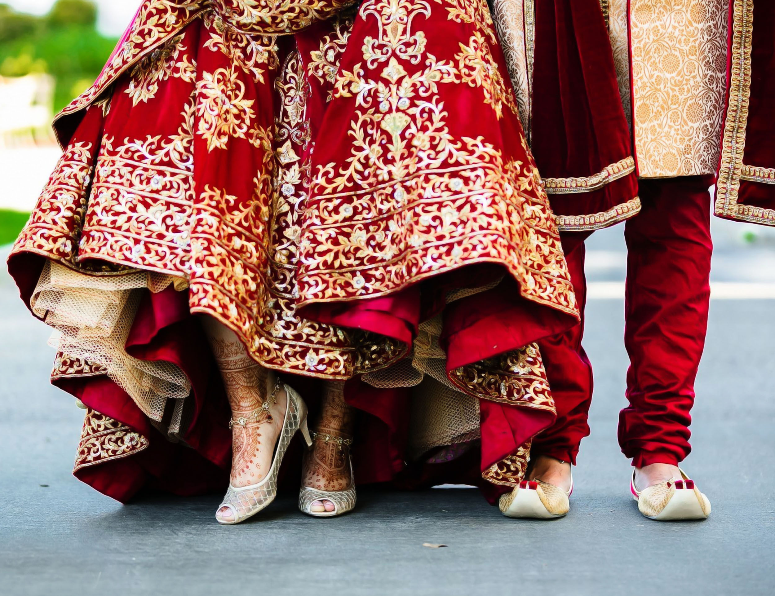 Bride in red lehenga and groom in wedding attire walking together